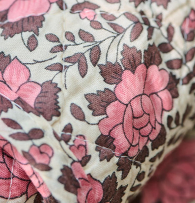 Bild av bomullsfilt med blommönster i rosa och brunt
