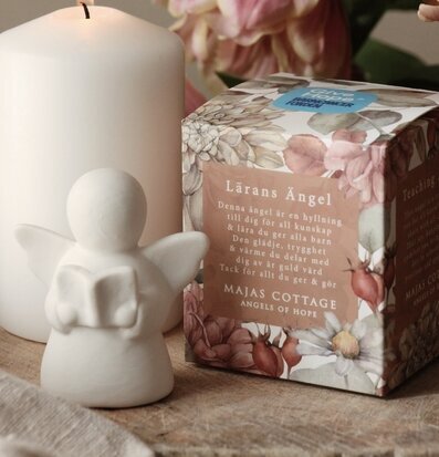 Bild av harmonisk scen med ängel, ljus och tulpaner