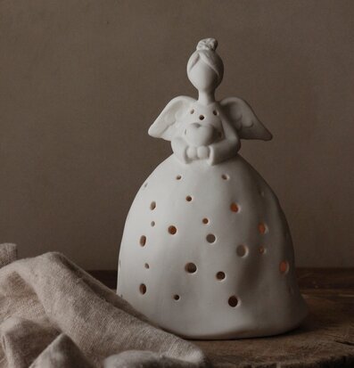 Foto av dekorativ ängelfigur med hjärta och ljuseffekt