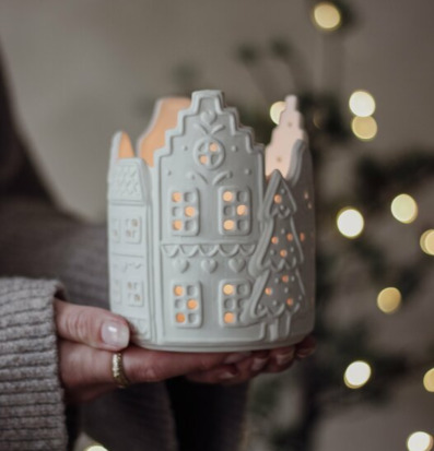 Foto av detaljrik ljushållare som påminner om pepparkakshus