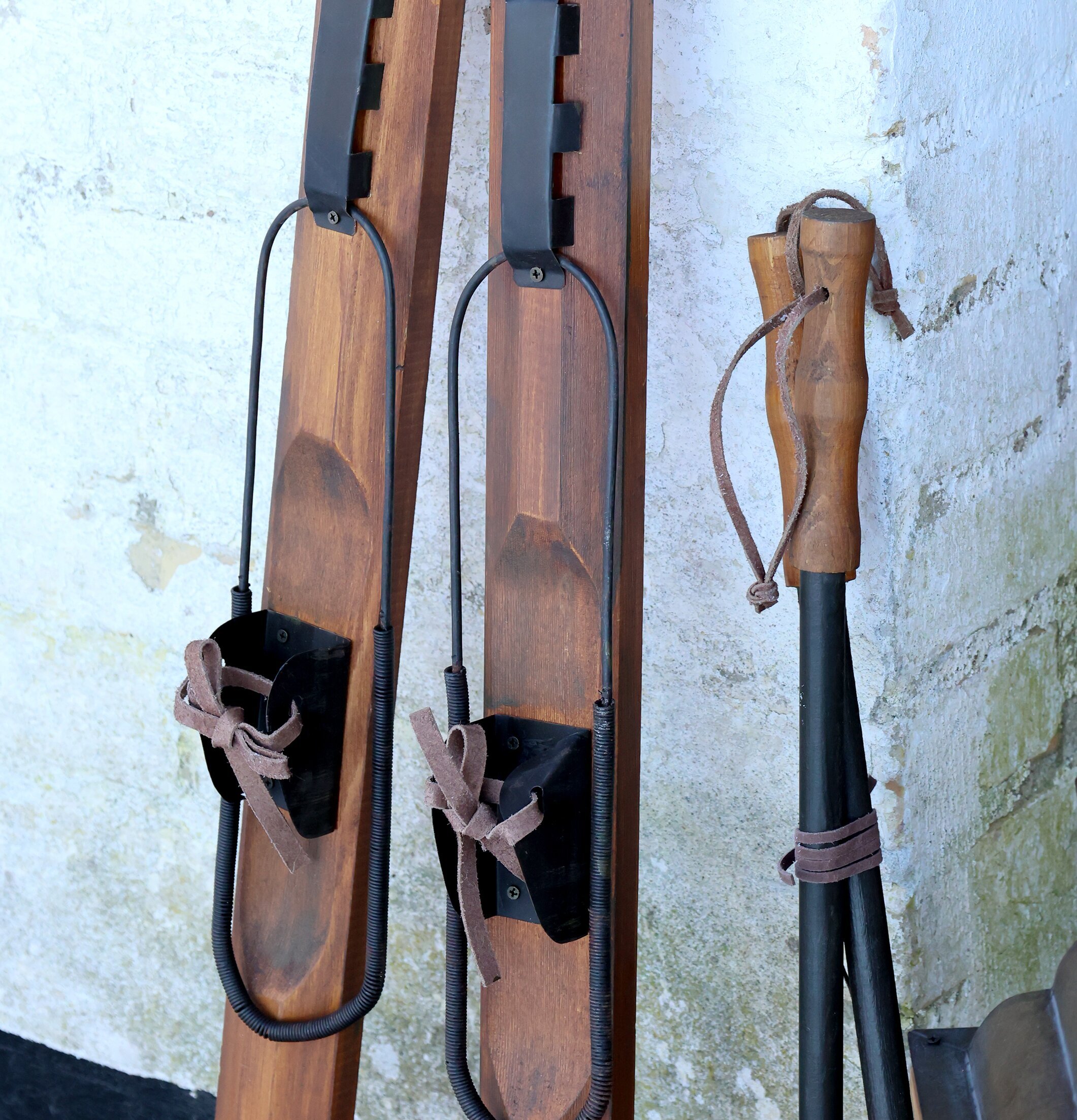 Bild av vintage skidor och stavar mot vitkalkad vägg