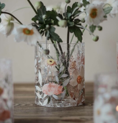 Bild av ljuslykta med blommotiv på rustikt träbord