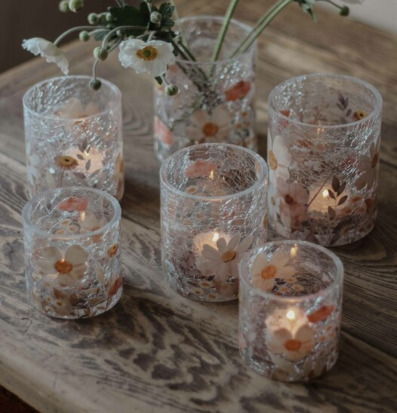 Bild av ljuslyktor och blommor på rustikt träbord