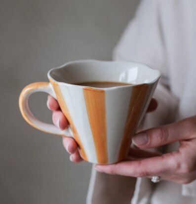 Bild av stilfull kopp med harmoniska ränder i ockra