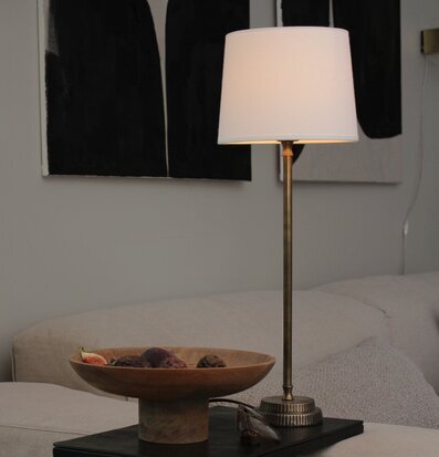 Bild på stilrent vardagsrum med elegant bordslampa
