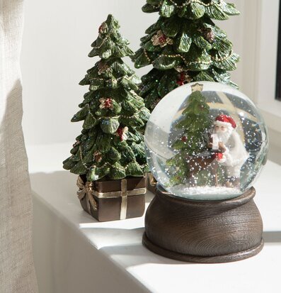 Foto av juldekorationer med granar och snöglob i fönster