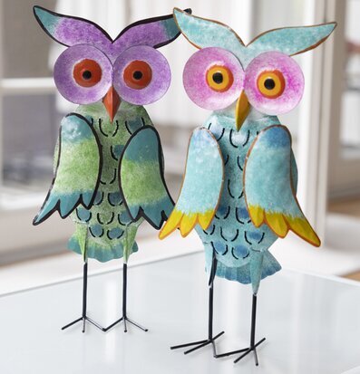 Bild av färgglada ugglor i hamrad plåt på vit yta