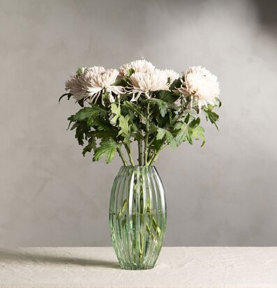 Bild av stilren vas med blommor i naturnära färger