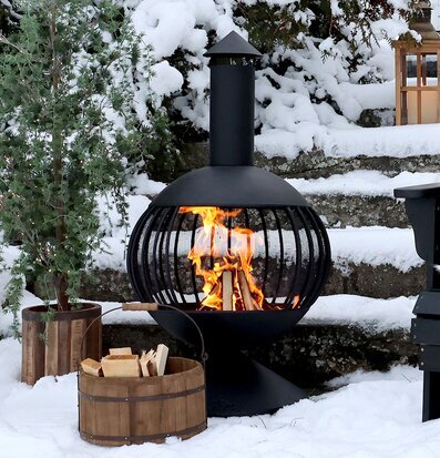 Bild av vinterträdgård med eldstad och snöklädda detaljer