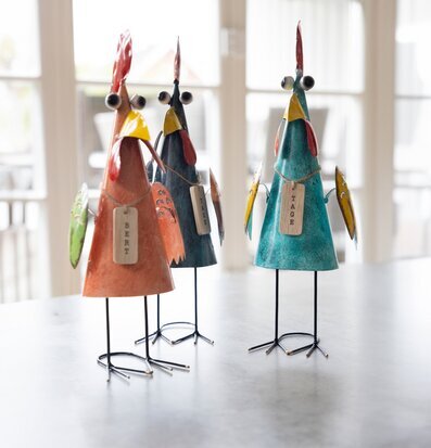 Bild av tre färgglada tuppfigurer i plåt och deras detaljer