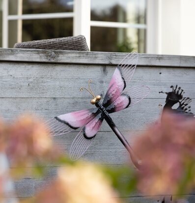 Bild av detaljrik metalltrollslända i rustik miljö