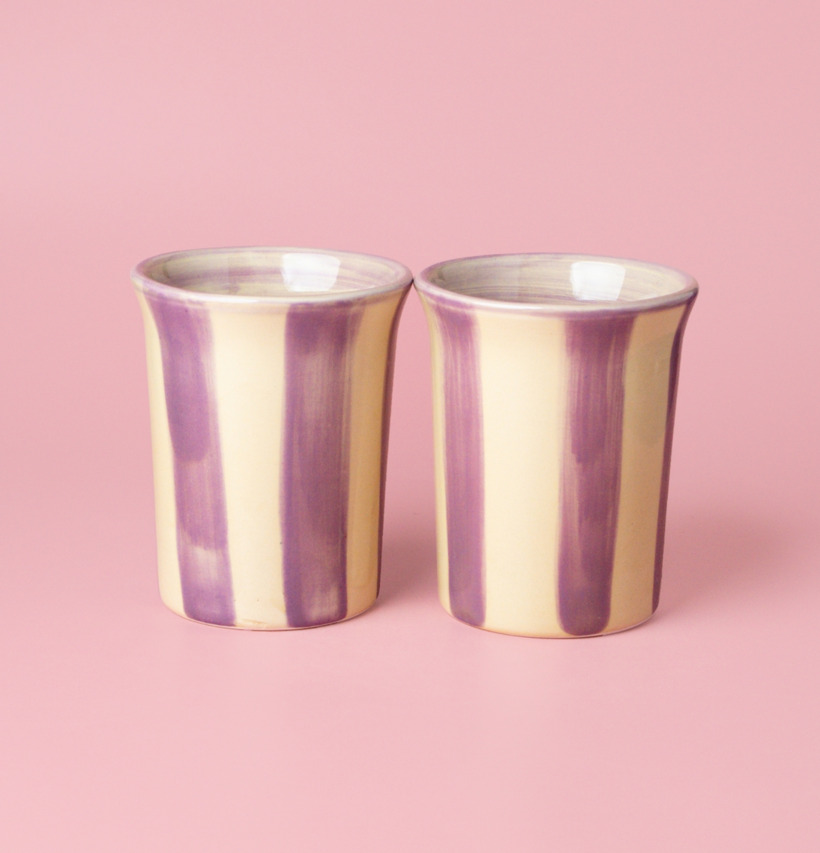 Bild av keramiska koppar med krämiga och lila toner