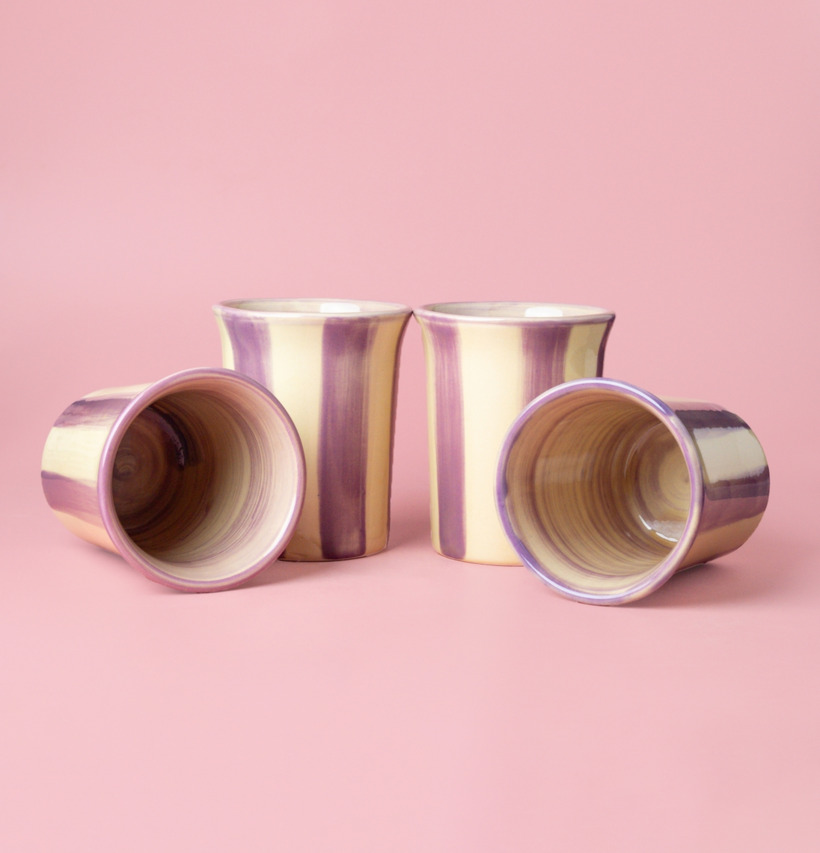 Bild av fyra keramiska koppar i kräm och lila nyanser