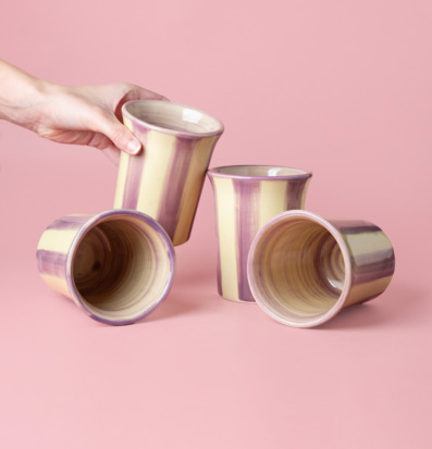 Foto av fyra unika keramiska koppar i lila och creme