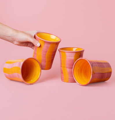 Bild av livfulla keramiska koppar i rosa och gult