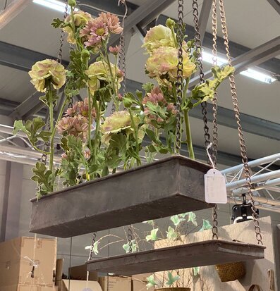 Bild av hängande metallhylla med konstgjorda blommor