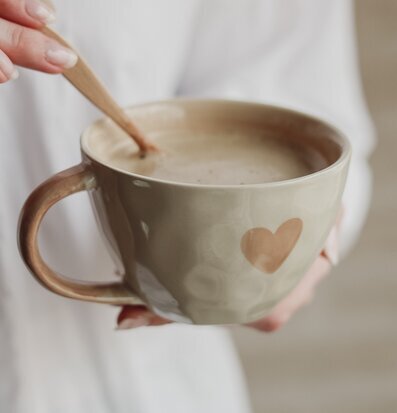 Foto av en elegant mugg med hjärtdetalj och träsked