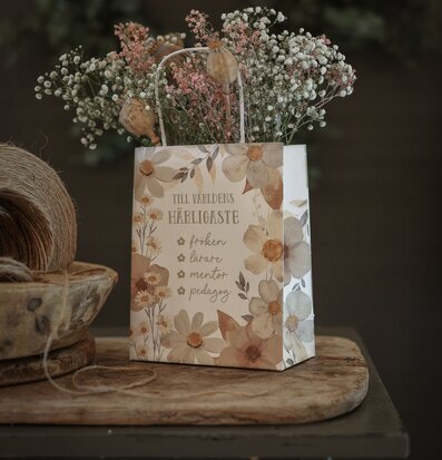 Bild av gåvopåse med blommigt mönster och torkade blommor