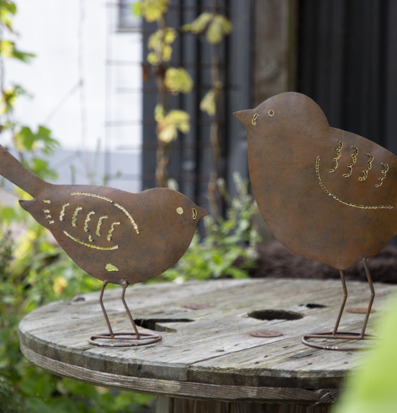 Bild av konstnärligt utformade fåglar i trädgårdsmiljö