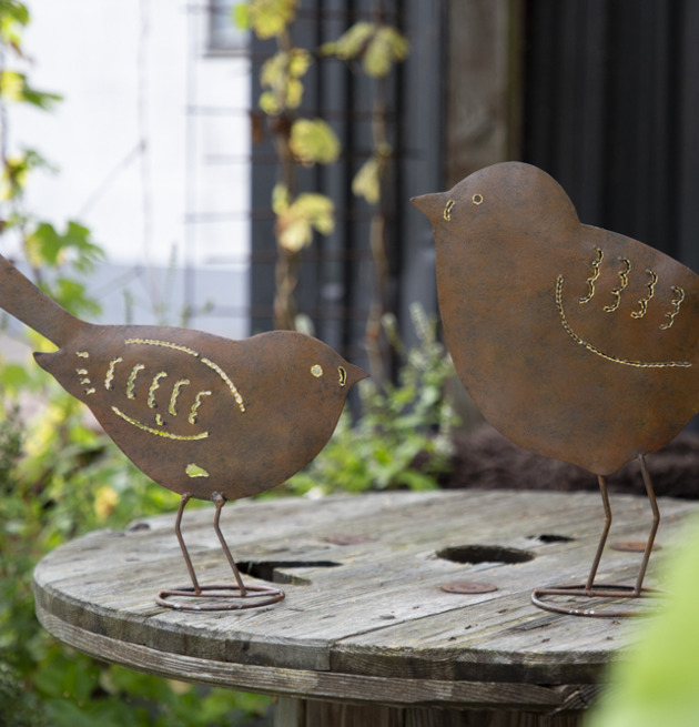 Bild av konstnärligt utformade fåglar i trädgårdsmiljö