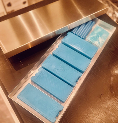 Bild av stilren kylplatta med blå detaljer och träbakgrund