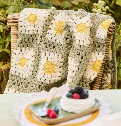 Bild av rofylld lantlig miljö med virkad pläd och dessert