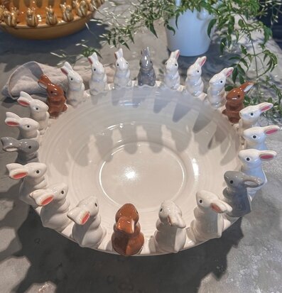 Bild av keramikskål med kaninfigurer och grön växt