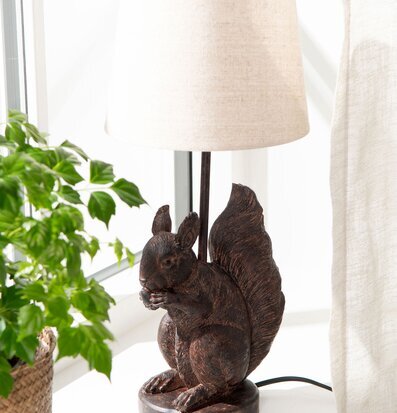 Bild av dekorativ lampfot med ekorre och krukväxt