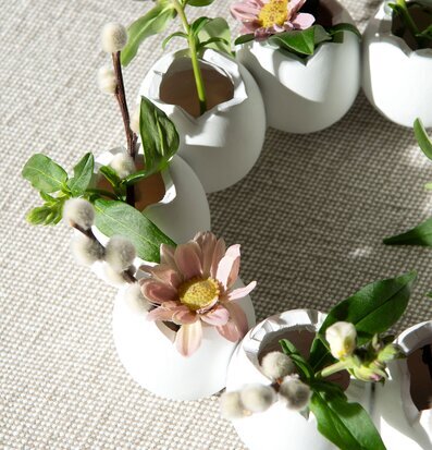 Bild av dekorativ äggkrans med blommor och växter