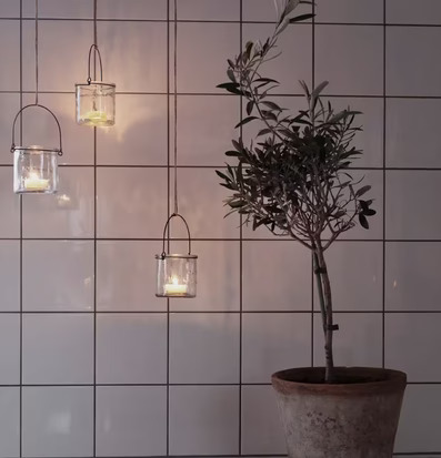 Ernst Hängande Lykta 0.25L mot vit kakelvägg med växt