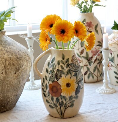 Foto av dekorativ kanna med blommotiv och eleganta detaljer