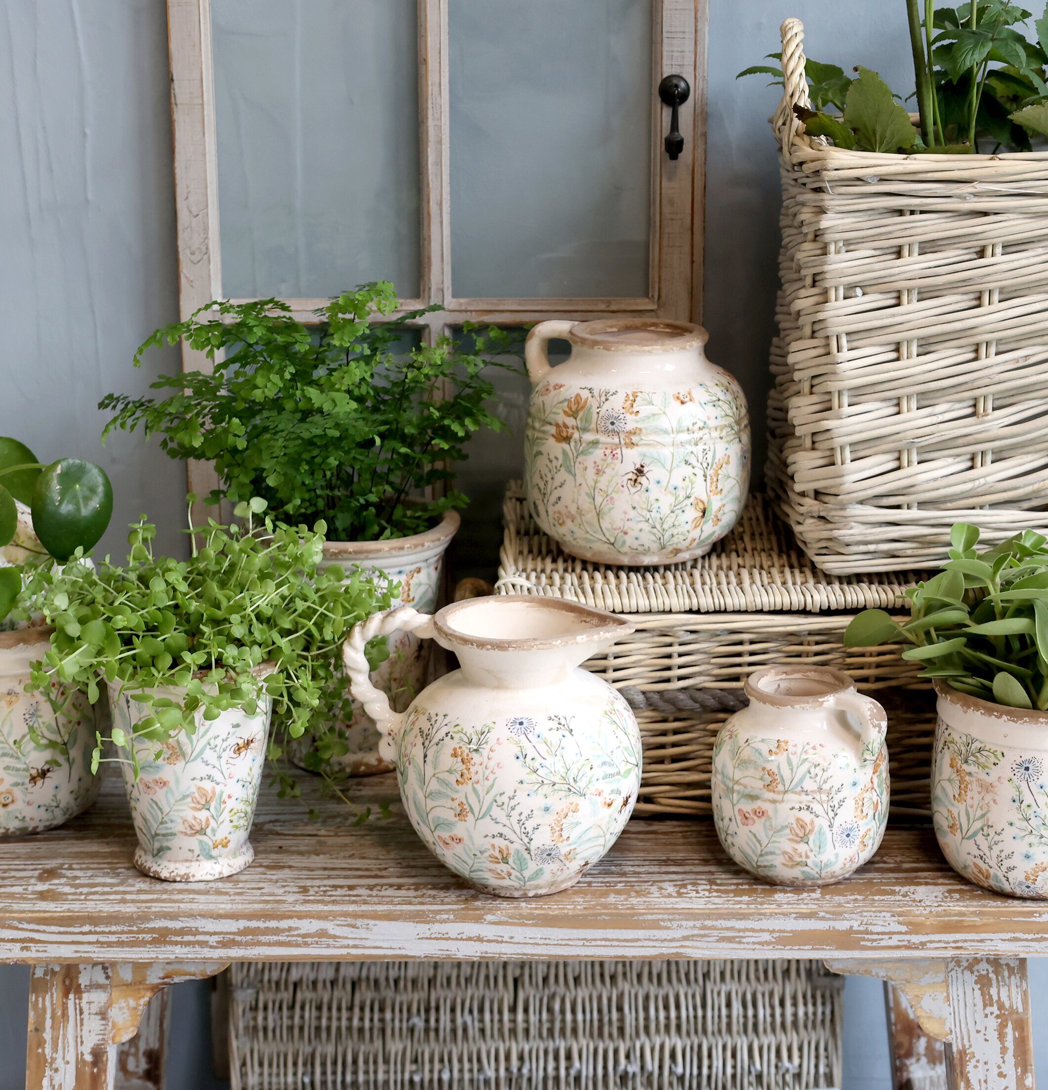 Bild av hemtrevlig inredning med kannor och blommor