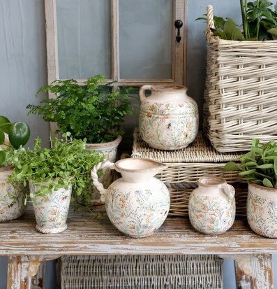 Bild av hemtrevlig inredning med kannor och blommor