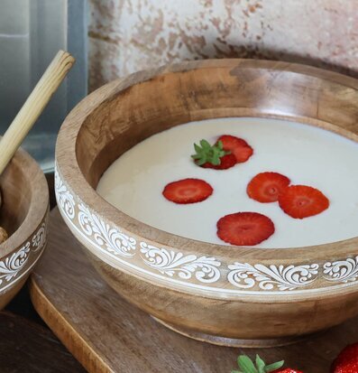 Bild av elegant träskål med jordgubbar och tegelvägg