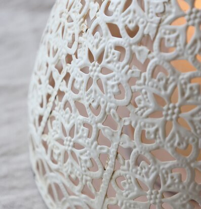 Foto av ljuslykta med spetsmönster och vintagekänsla