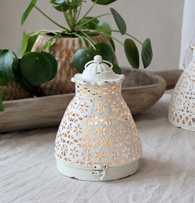 Bild av elegant ljuslykta med antik finish och växter