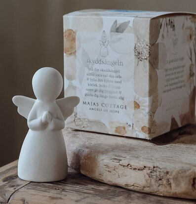 Foto av harmonisk scen med ängel och elegant gåvobox