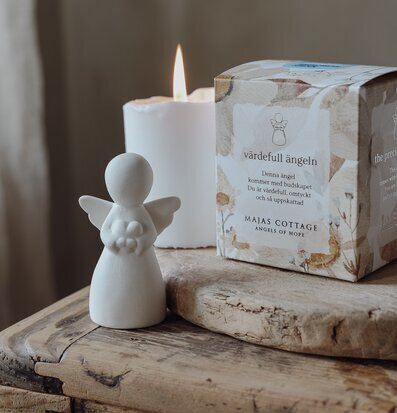 Bild av ängel och gåvobox i harmonisk heminredning