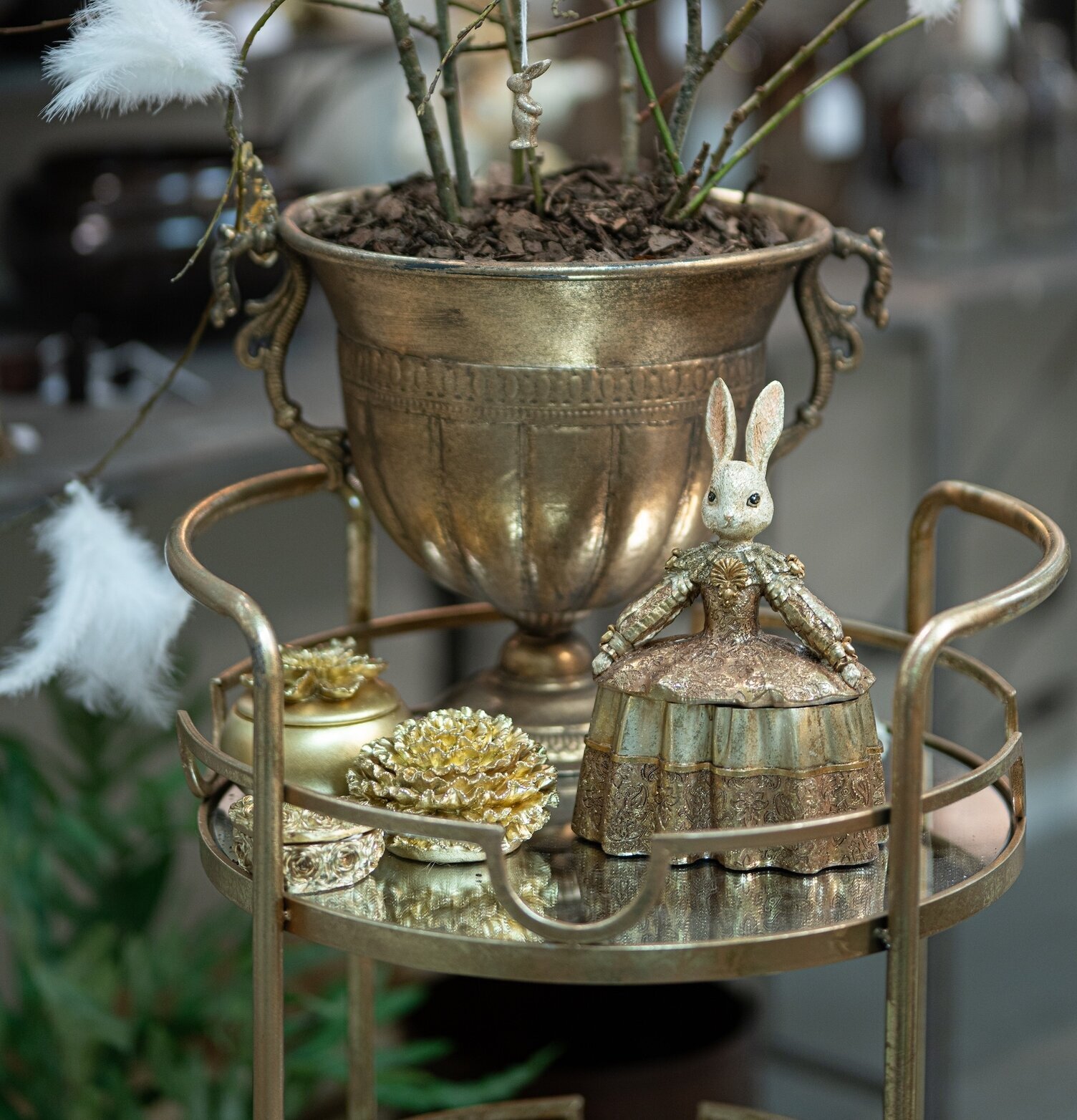 Bild av elegant arrangemang med gyllene urna och dekor