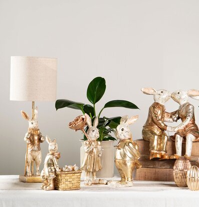Bild av charmiga dekorativa kaninfigurer och växter