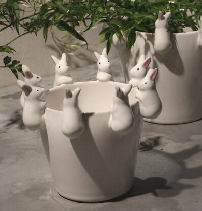 Bild av fantasifull vit kruka med kaniner och grönska