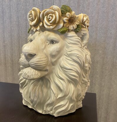 Bild av dekorativ kruka med lejonhuvud och blommor