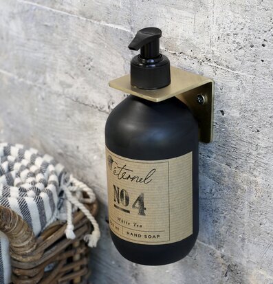 Bild av stilfull vägginstallation med glasflaska i mässing