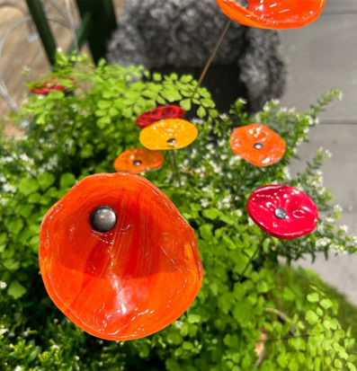 Bild av färgglada glasblommor i naturlig miljö