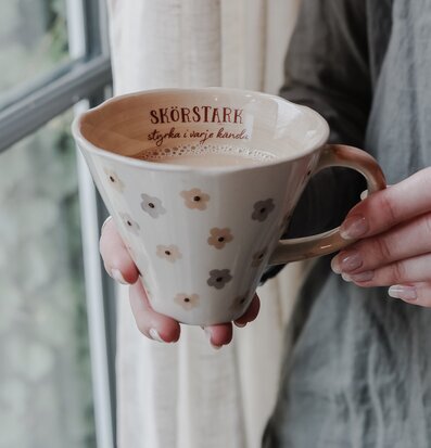 Bild av keramikmugg som förmedlar värme och hemtrevnad