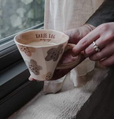 Bild av en mugg med inspirerande text och blommönster