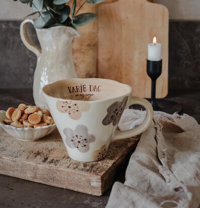 Bild av hemtrevligt bord med mugg, kakor och ljusstake