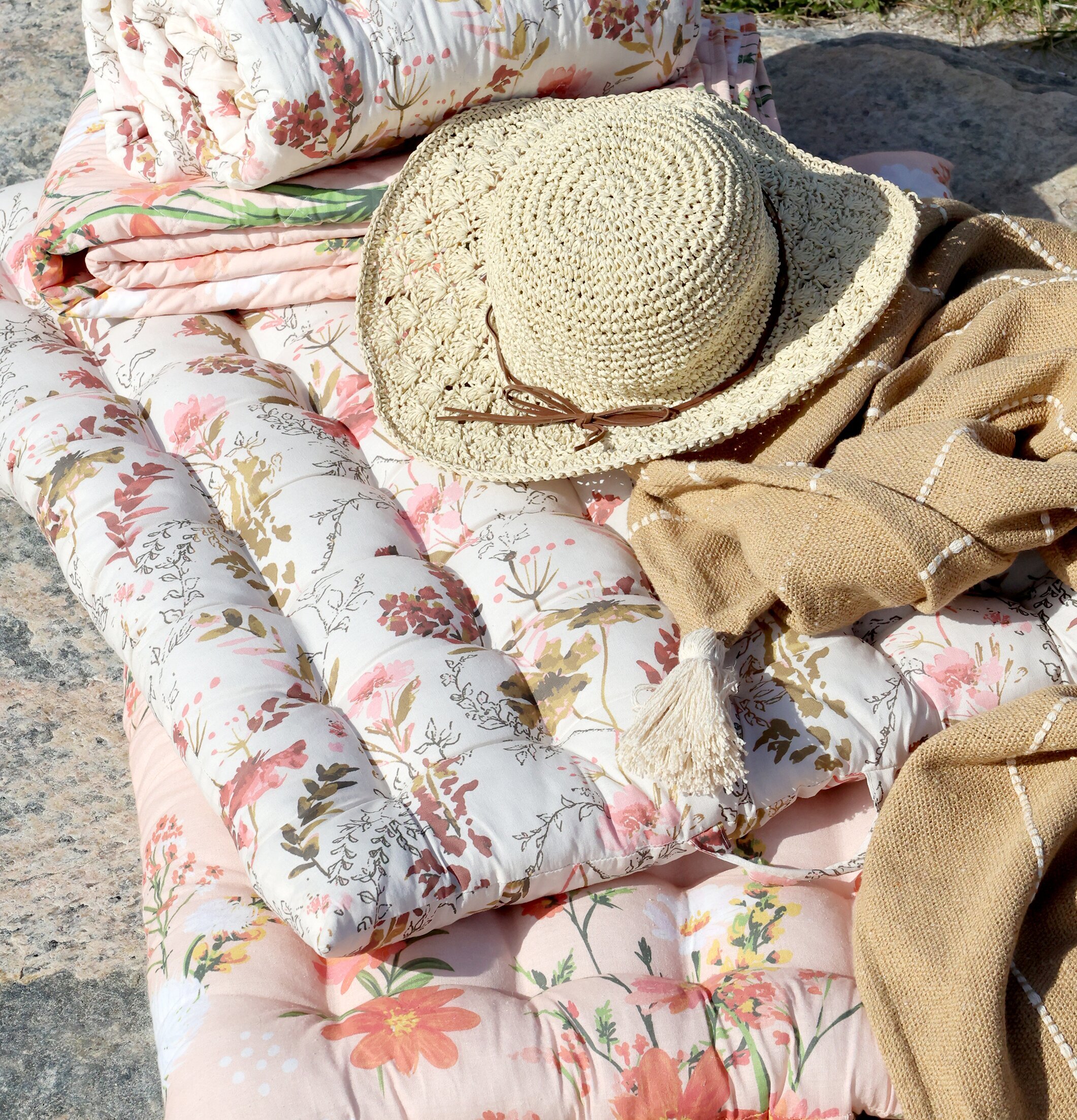 Bild av inbjudande madrass med blommönster och stråhatt