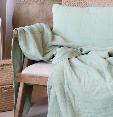 Bild av harmonisk interiör med grön pläd och fåtölj