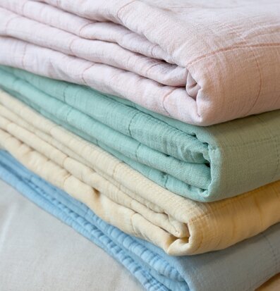 Bild av fyra vackert vikta plädar i harmoniska färger